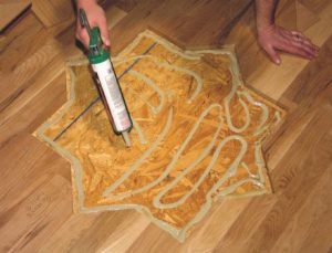 Photo 7: Apply adhesive to the subfloor in a thickness that will match the overall elevation of the floor.