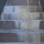 Moisture migration from voids underneath stone tiles with visual efflorescence.