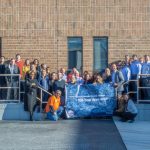 Employees from Tarkett and Fishman Flooring Solutions proudly display the banner celebrating Fishman’s 100 years of business success.