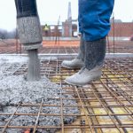 Construction workers pouring cement on roof