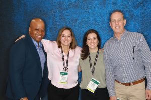 Posing at the Coverings Happy Hour photo booth are Custom staff (left to right) Eric Carr, Diane Stewart, Lori Powell and Don Munro.