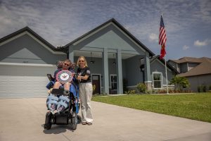 U.S. Marine Corps. Lance Cpl. John โJ.T.โ Doody in front of his new R.I.S.E. home in Parrish, Fla.
